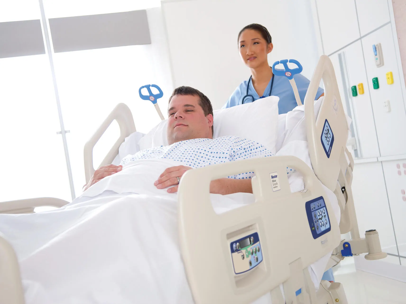 An obese patient in a Compella bariatric bed being wheeled by a single Healthcare Professional