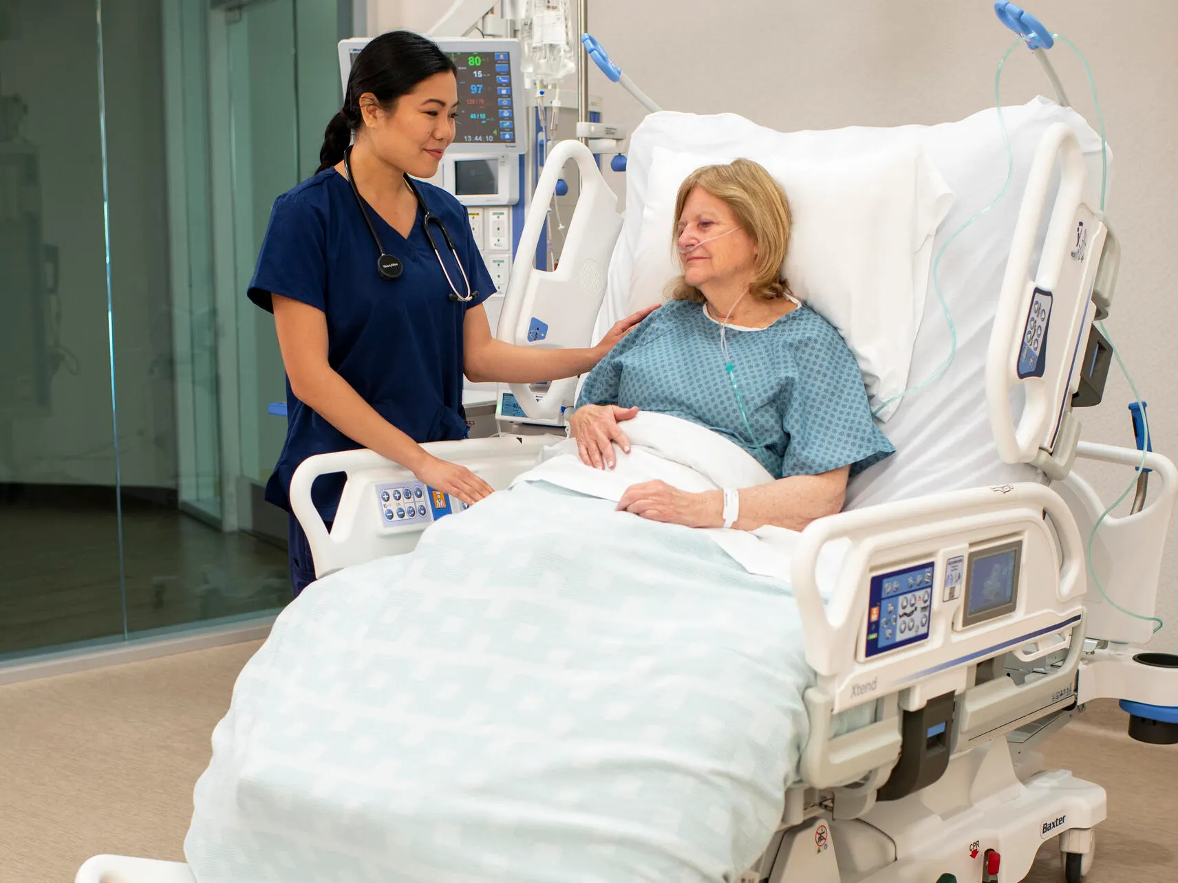 Healthcare professional comforts patient in the Progressa bed in the seated position