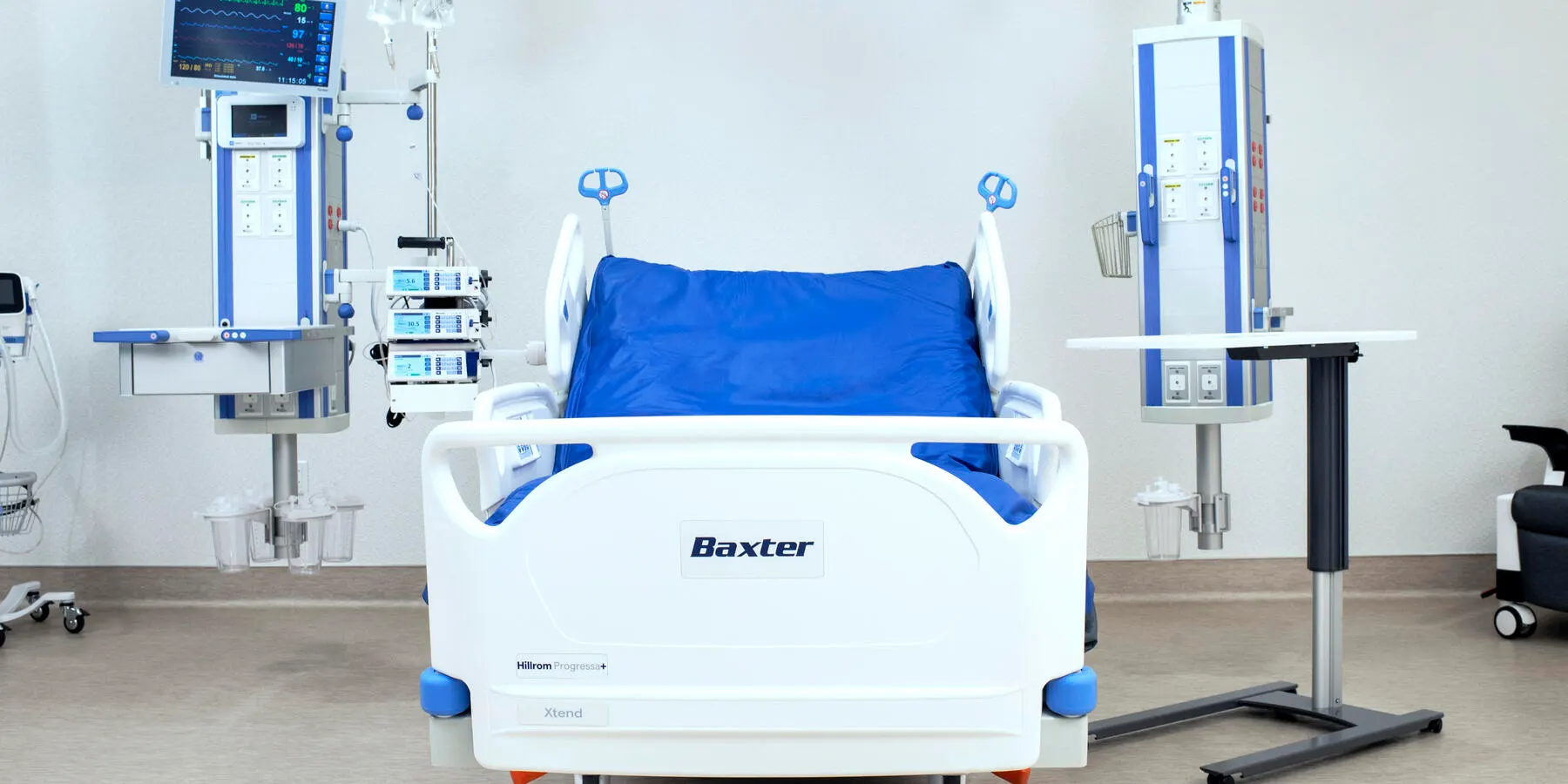 Baxter hospital bed in a room with two equiment booms and some infusors