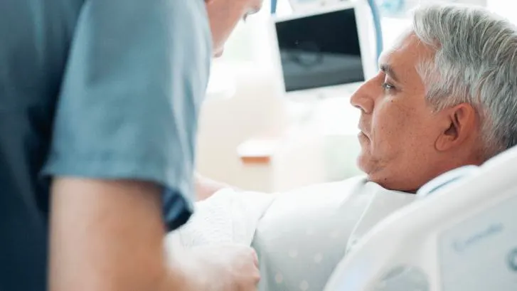 Close-up of nurse covering a patient with a blanket