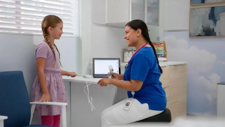 Pediatric child being seen by caregiver in a primary care office
